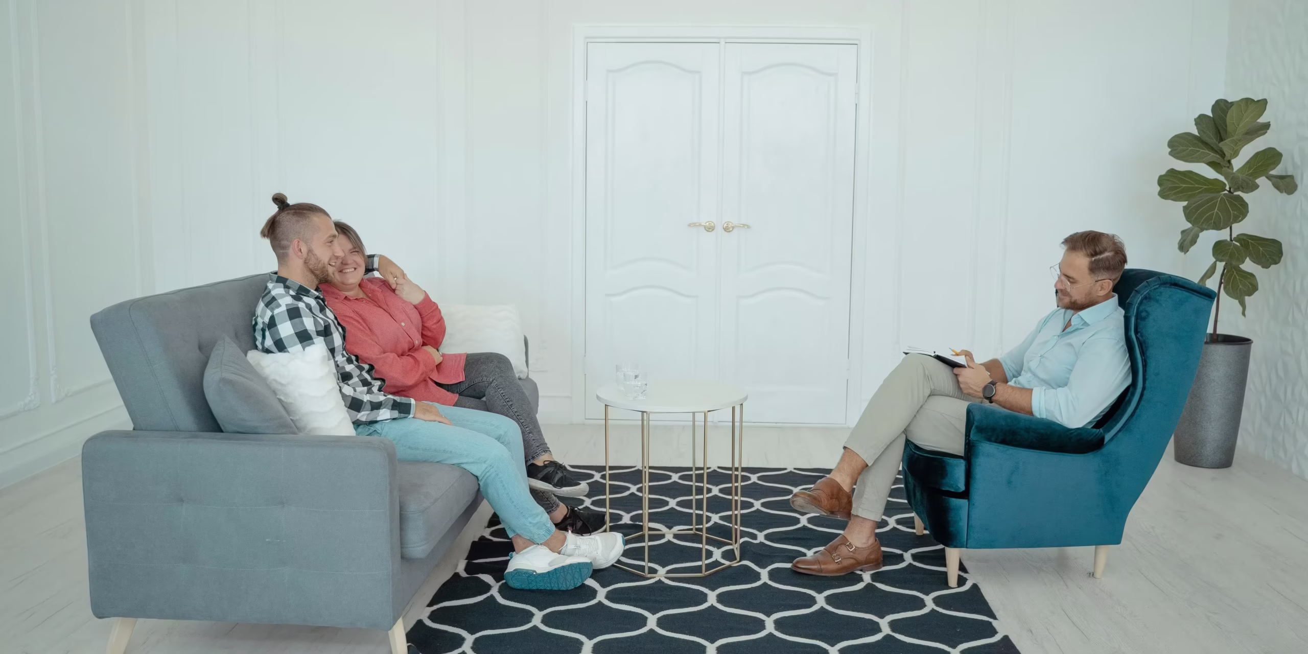 marraige counseling The image depicts an indoor scene, likely a professional or therapeutic setting, with three individuals present.
