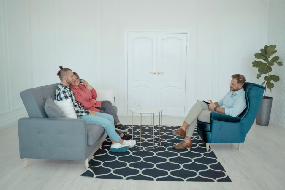 marraige counseling The image depicts an indoor scene, likely a professional or therapeutic setting, with three individuals present.